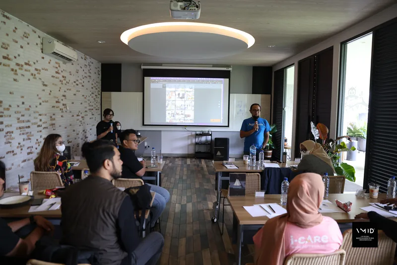 Participants at long tables facing a speaker and a projected slide in a training room — CAMP 2023, PT. Agrinesia Raya